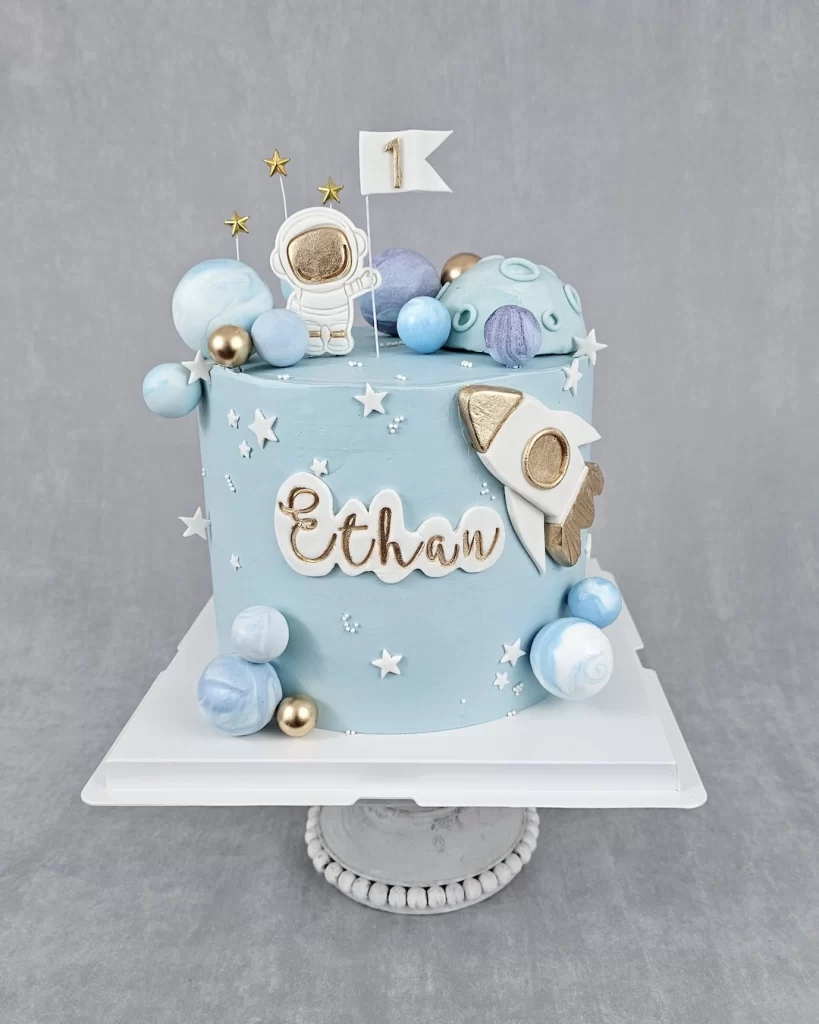 An astronaut-themed birthday cake decorated with planets, stars, and a space design