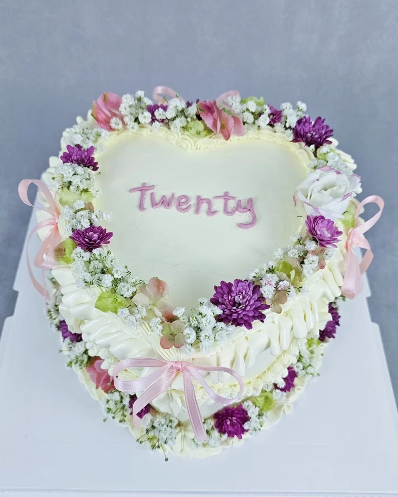 Elegant heart-shaped cake decorated with fresh flowers