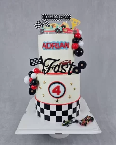 A race car-themed birthday cake decorated with cars and racing elements