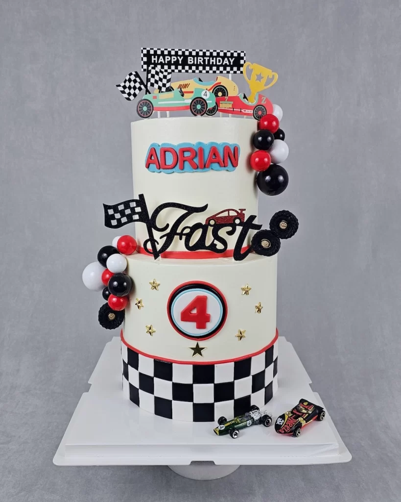 A race car-themed birthday cake decorated with cars and racing elements
