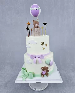 Two-tier cake decorated with cute bears and colorful balloons