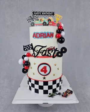 A race car-themed birthday cake decorated with cars and racing elements