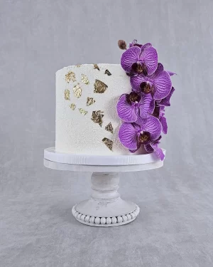 Tall Cake Designed with Purple Orchids Elegant Tall Cake Adorned with Purple Orchid Decorations - Contact Fancy Cakes Ottawa to Learn More